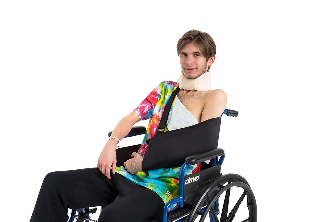 Patient wearing a shoulder snap adaptive shirt after shoulder surgery while recovering with an arm sling