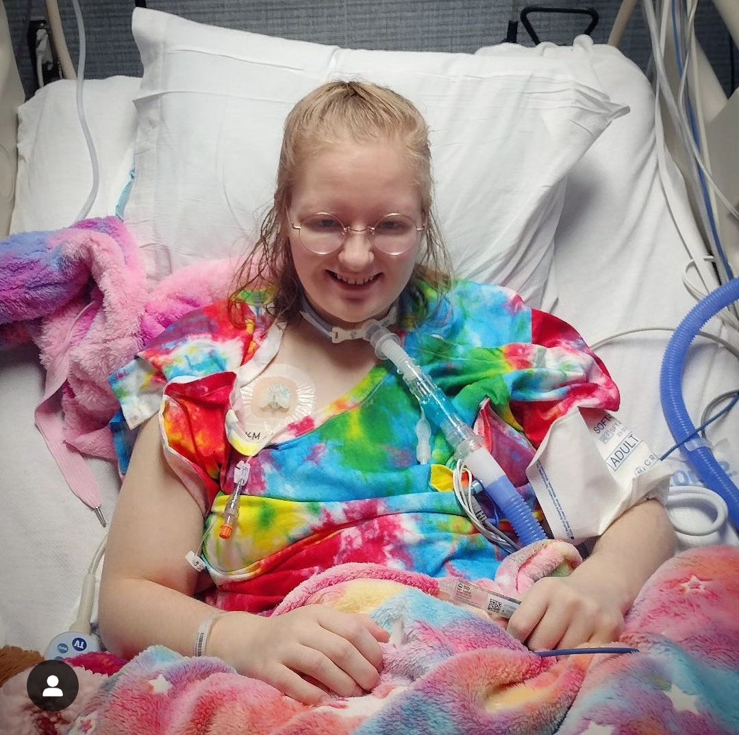 Women in a hospital bed wearing a colorful outfit with medical equipment.